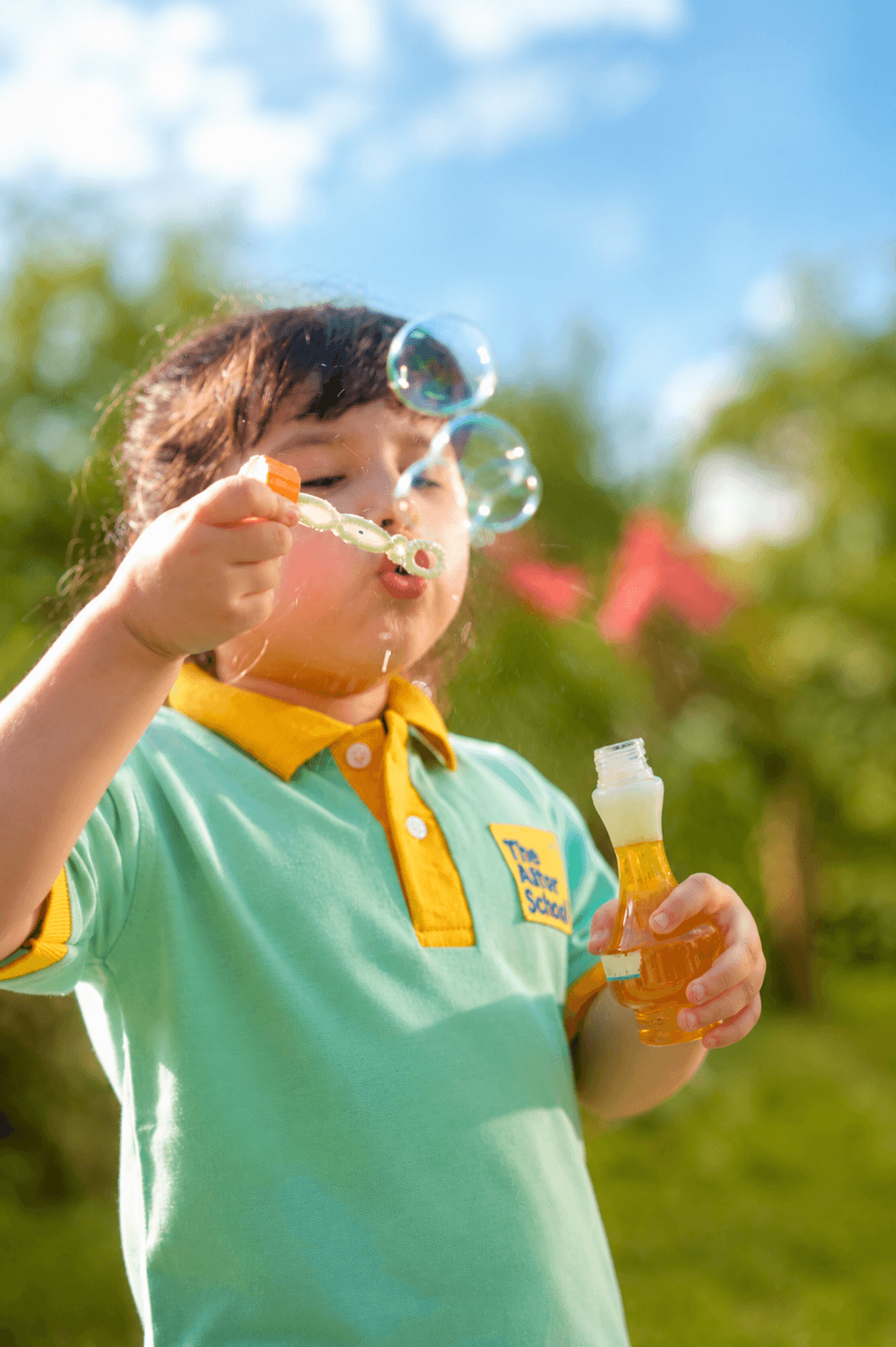 A child blowing bubbles outdoors at Aster