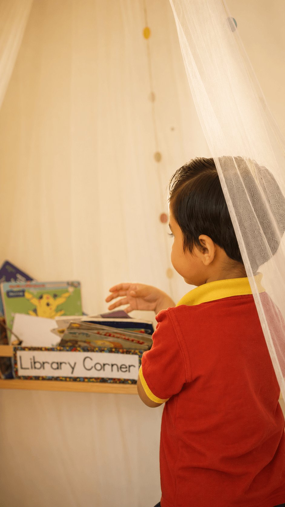 A child exploring the library corner at Aster